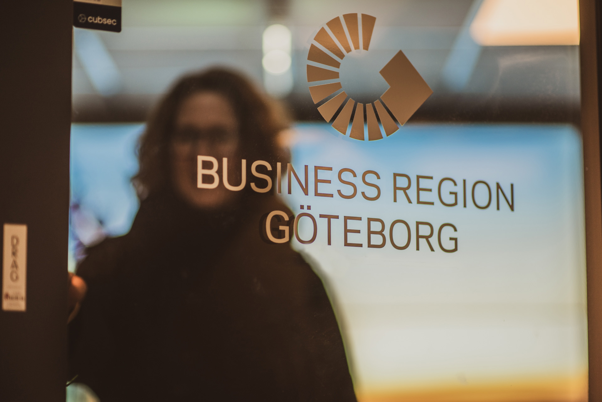 Kvinna öppnar en dörr med  logotyp Business Region Göteborg. 